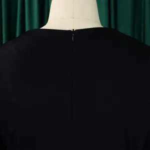 Detail view of the back invisible zipper on a solid black high-waisted dress