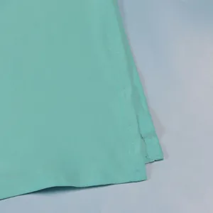 Close-up of double-stitched split detail on a mint green stretch bodycon midi skirt.