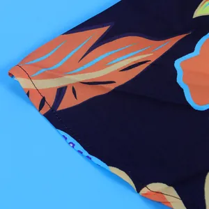 Close-up macro view showing tropical leaf print and fine stitching on the fabric edge