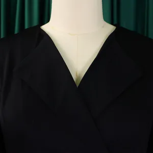 Detail view of the elegant black V-neck overlapping collar design on a stylish dress