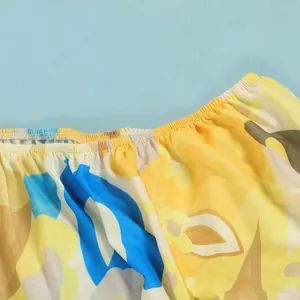 Close-up of gathered neckline on floral print dress with vibrant yellow and blue pattern