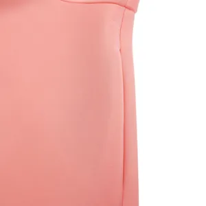 Close-up detail showing the smooth pink fabric texture and fine stitching of the dress.