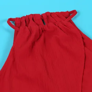 Close-up macro view of vibrant red textured fabric showing the halter drawstring neckline detail
