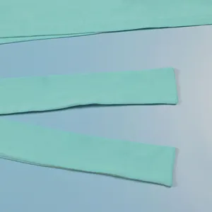 Close-up detail of mint green stretch bandage fabric and straps of a midi dress set