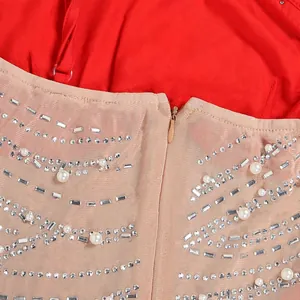 Dettaglio macro di eleganti decorazioni con perle e strass su tessuto a rete rossa trasparente