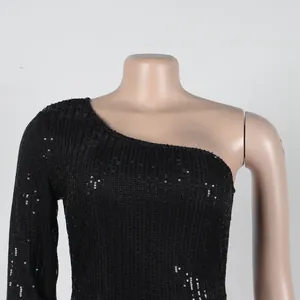 Detailed view of black sequin one-shoulder dress showing shimmering vertical texture