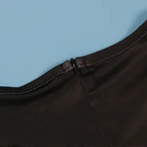 Primer plano de la cremallera invisible en un elegante vestido largo negro.