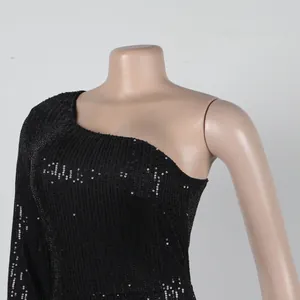 Detailed macro view of black one-shoulder sequined cocktail dress with shimmering texture
