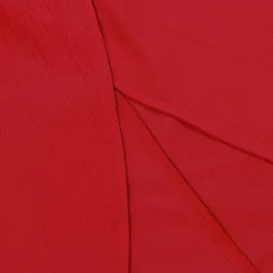 Macro detail showing the vibrant red fabric texture and split hem of the sleeveless set.