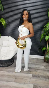 Eleganter weißer trägerloser Jumpsuit mit weitem Bein und goldenen Knöpfen am Model.