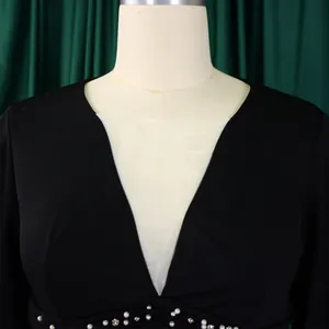 Close-up of black jumpsuit featuring mesh V-neckline and elegant pearl embellishments