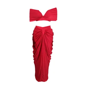 Detail view of a vibrant red two-piece ruched skirt and bandeau crop top set