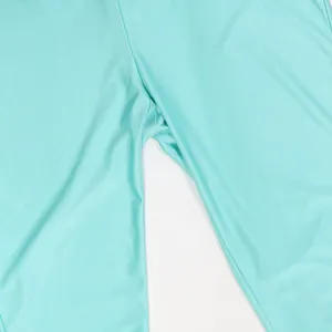 Primo piano dei dettagli delle cuciture e del tessuto verde acqua della tuta corta donna.
