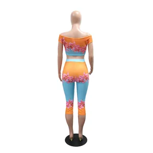 Detailed back view of vibrant floral lily print off-shoulder crop top and leggings set