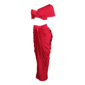 Detailed view of a vibrant red two-piece ruched crop top and maxi skirt set.