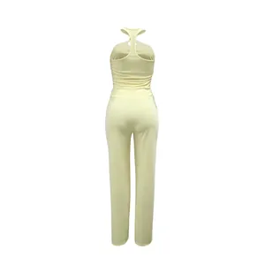 Vista posteriore di un elegante completo giallo due pezzi con scollo halter e pantaloni