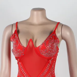 Detalle de vestido rojo sexy con pedrería y escote en V de malla para discoteca