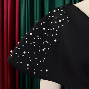 Close-up of pearl and bead detailing on a black v-neck banquet evening dress