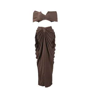 Two-piece set featuring brown bandeau top and draped pleated floor-length maxi skirt