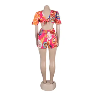 Detailed back view of a vibrant floral print romper featuring a tie-back and ruffle sleeves.