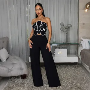Ensemble noir élégant avec haut tube à fleurs et pantalon large porté par un mannequin.
