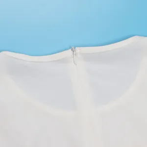 Primer plano detallado del cuello trasero con cremallera invisible en un vestido blanco.