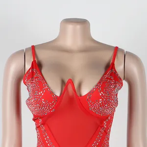 Primer plano de vestido rojo de tirantes con intrincados patrones de pedrería y malla.