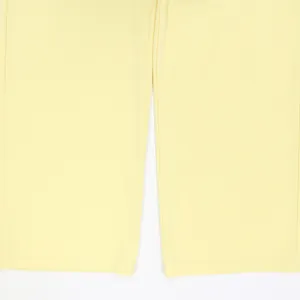 Dettaglio dei pantaloni gialli a vita alta a gamba larga, tessuto e orlo visibili