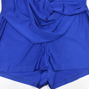 Dettaglio della tutina blu con scollo all'americana e tessuto drappeggiato