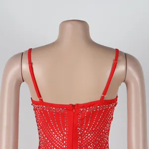Detalle de vestido rojo con pedrería y tirantes finos con cremallera en la espalda.