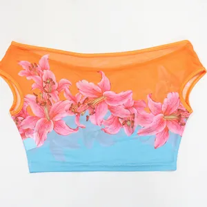 Detail view of the pink lily print and mesh fabric on a vibrant floral crop top.