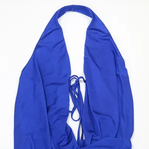 Dettaglio di una tuta intera blu con scollo all'americana e chiusura con laccetti frontali.