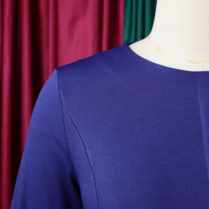 Gros plan d'une robe bleue à col rond montrant les détails de la texture du tissu fin
