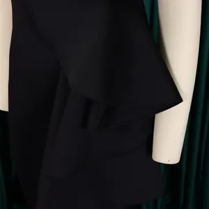 Macro view of elegant black evening dress peplum ruffle detail showing fabric texture
