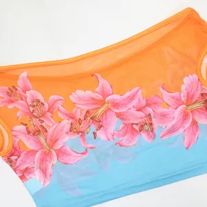Detailed macro view of pink lily floral print on orange and blue gradient mesh top