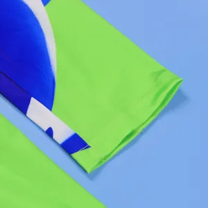 Macro view showing the vibrant green and blue abstract print and fine stitching detail.