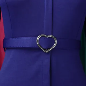 Détail en gros plan d'une boucle argentée en forme de cœur sur une robe crayon violette