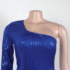 Detail shot of blue sequin one-shoulder dress showing intricate sparkle texture.