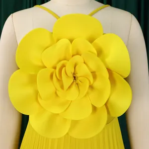 Close-up of large yellow 3D flower detail on elegant pleated sleeveless jumpsuit