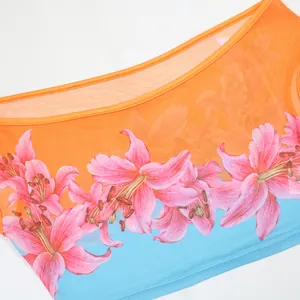 Detailed close-up of vibrant pink lily print on mesh fabric with orange and blue blocking.
