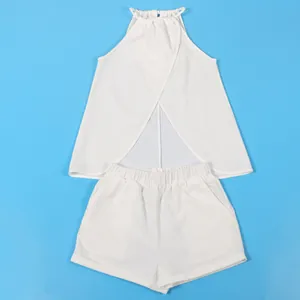 White halter neck sleeveless top and shorts set laid flat on blue background