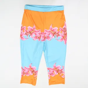 Front view detail of vibrant orange and blue floral printed high-waist cropped leggings
