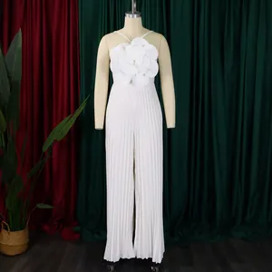 Detailed view of white pleated jumpsuit featuring a large 3D flower on the bodice