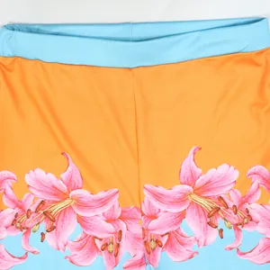 Close-up detail of high-waisted fashion pants featuring a vibrant pink lily floral print