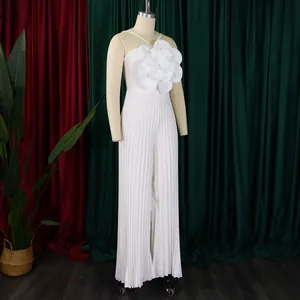 Close-up of white pleated jumpsuit featuring an oversized 3D flower embellishment.