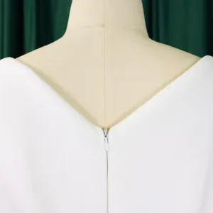Close-up detail of a white V-neck evening gown with a back zipper on a mannequin
