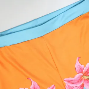 Macro detail of vibrant floral print high-waist pants with light blue elastic waistband