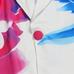 Macro detail showing the lapel and hot pink fabric button on a vibrant printed blazer.