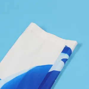 Detailed close-up of blue abstract print and stitching on white fabric sleeve hem