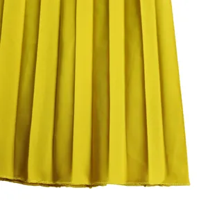 Macro close-up detail of vibrant yellow pleated fabric showing fine stitching and texture.